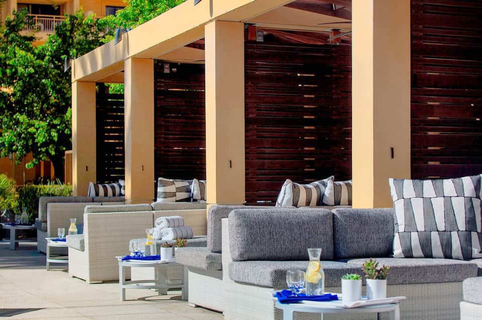 Modern resort lounge seating with gray furniture, striped pillows, and architectural elements