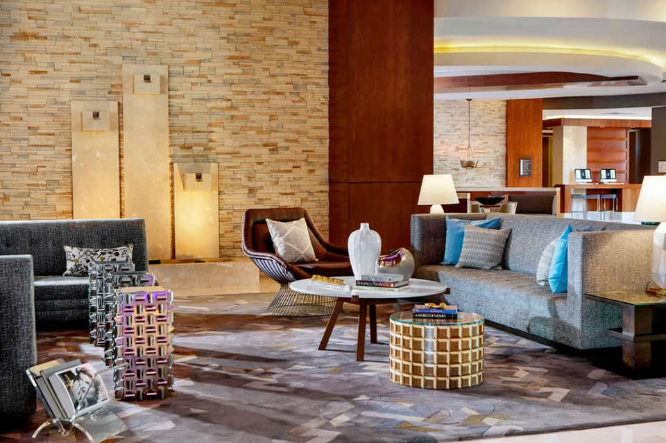 Contemporary hotel lobby with textured brick walls, modern furnishings, and warm lighting