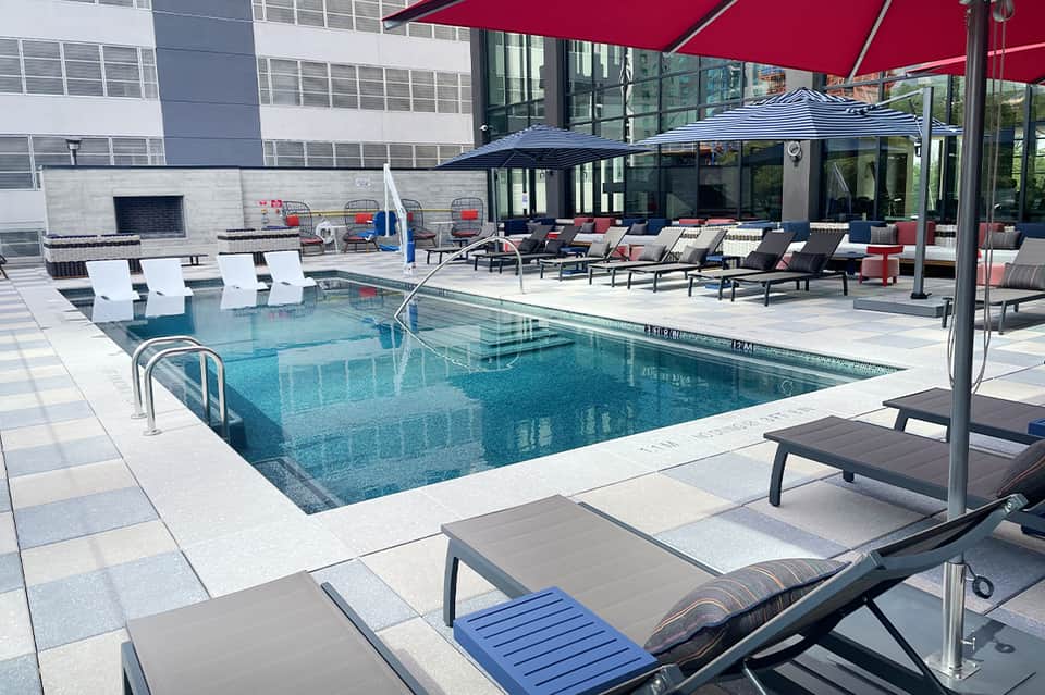 Contemporary urban pool with loungers under red and black umbrellas