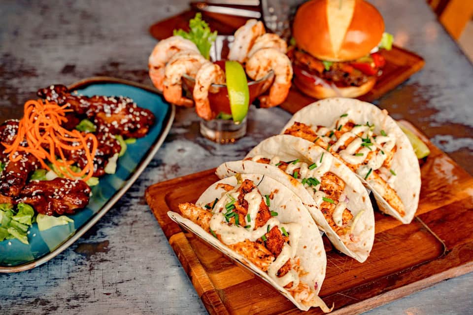 Gourmet seafood tacos and Asian dishes on wooden serving boards