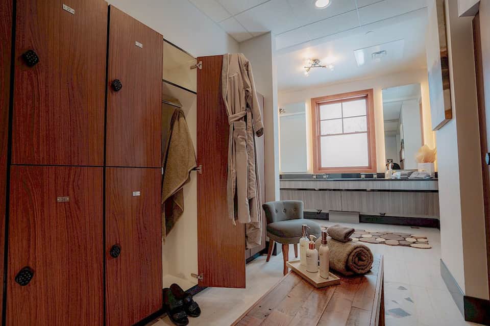 Luxurious spa bathroom with wooden vanity, soaking tub, and lounge seating area