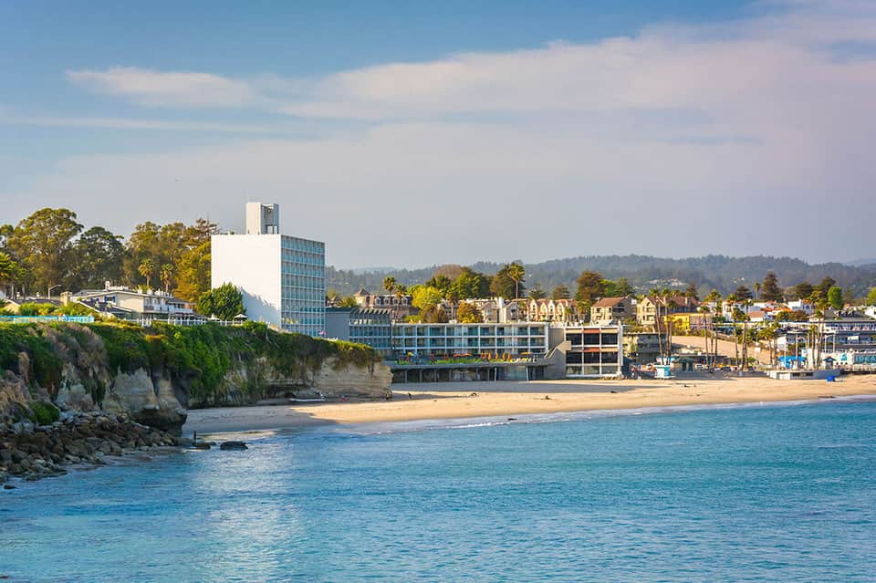 Beachfront hotel building on sandy coast with rocky cliffs and ocean view