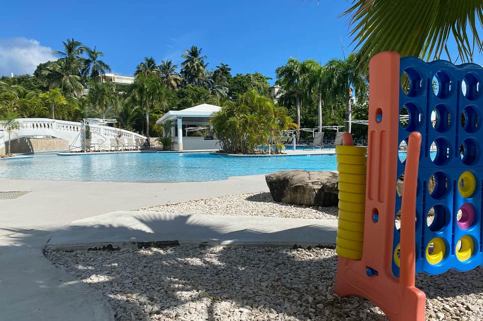 Family-friendly resort pool with colorful climbing structure and sandy beach area