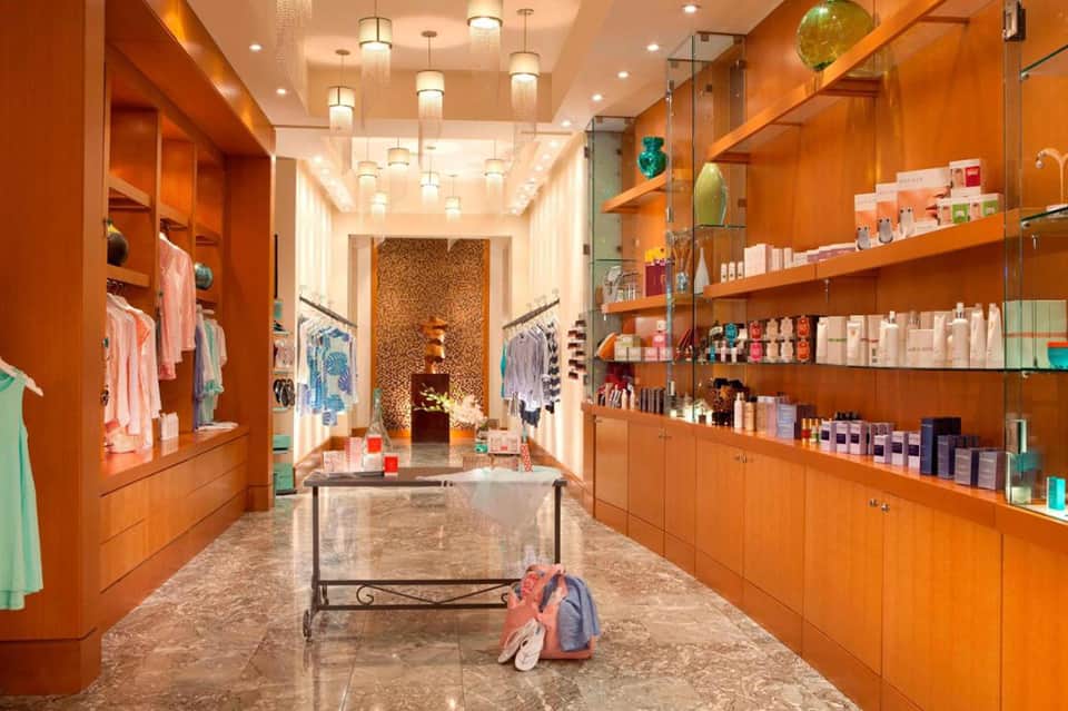 Bright orange retail boutique with shelving displaying clothing and beauty products throughout