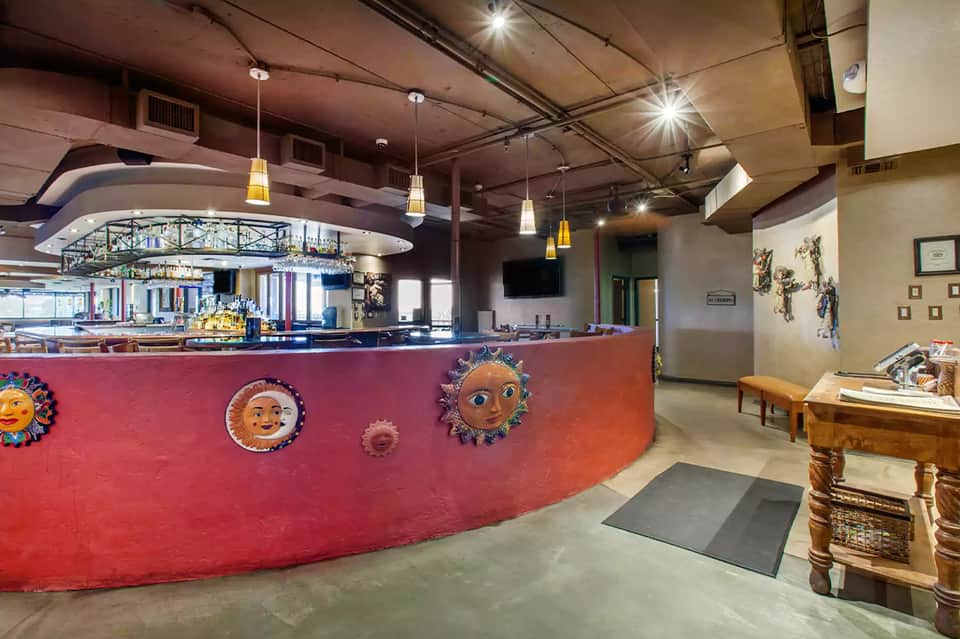 Colorful resort bar counter with decorative sun faces and modern pendant lighting
