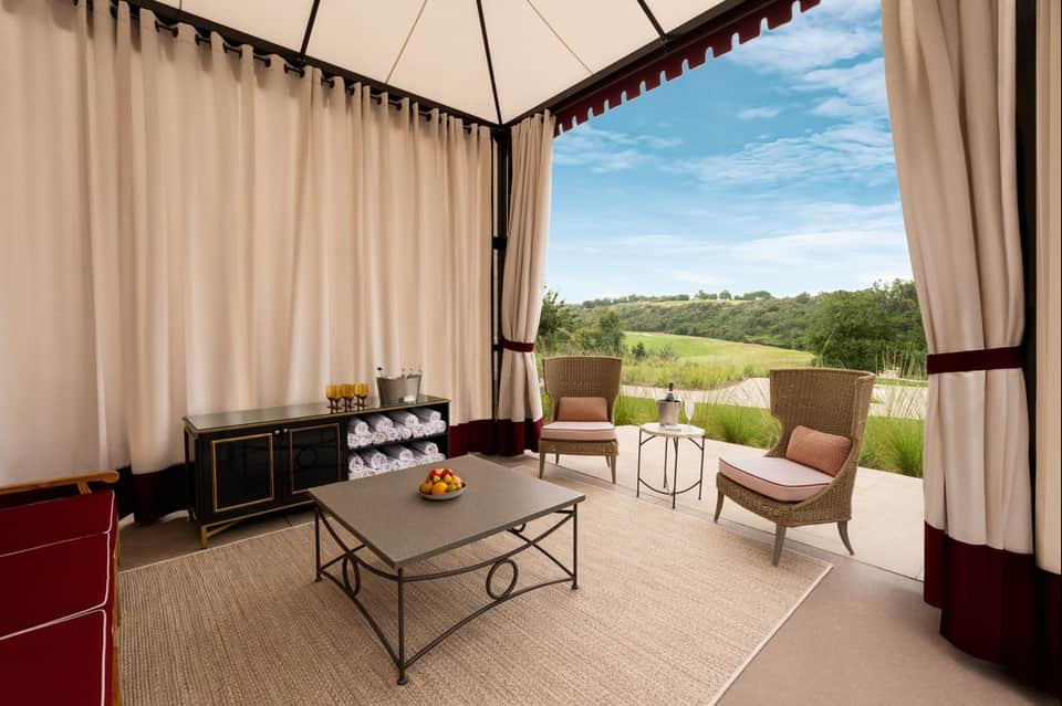Luxury pavilion with cream curtains overlooking rolling green countryside landscape