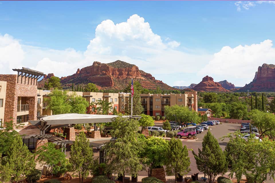 Desert resort courtyard with Southwestern architecture, red rock formations, and landscaped grounds