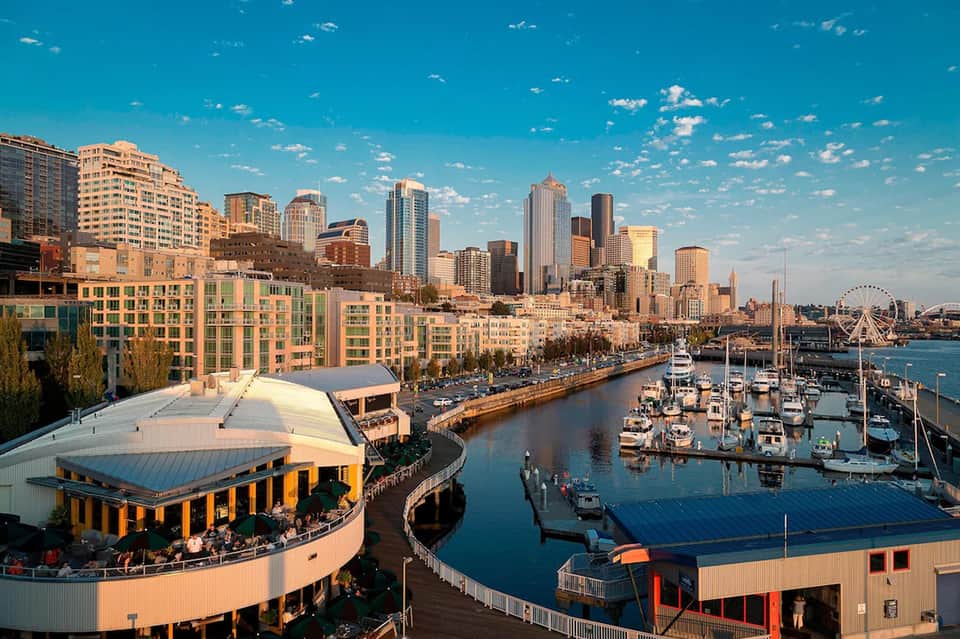 Waterfront cityscape showing marina, downtown skyline, and waterfront promenade at golden hour