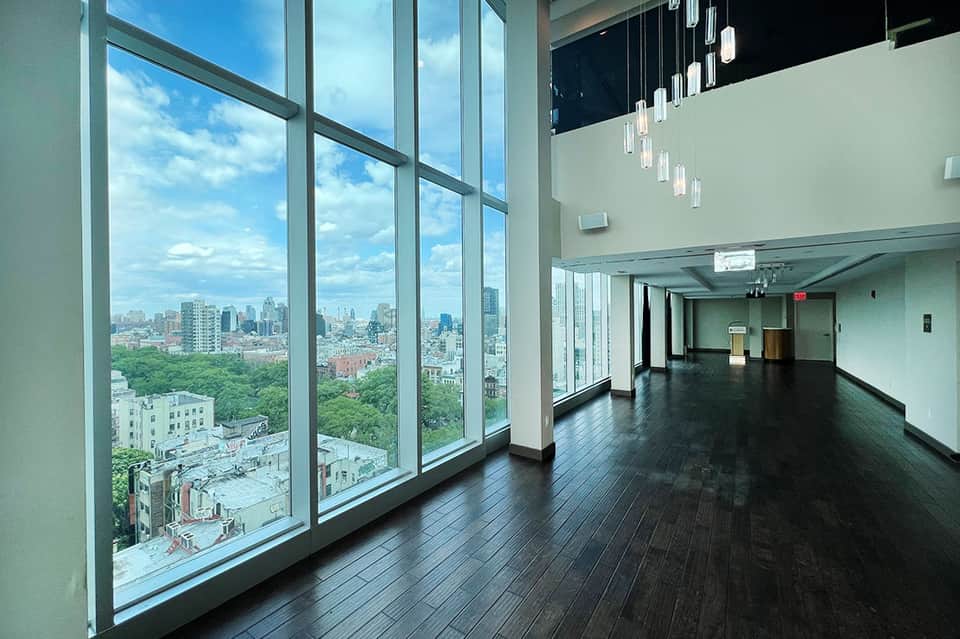 High-rise hotel event space with floor-to-ceiling windows overlooking city skyline and urban landscape