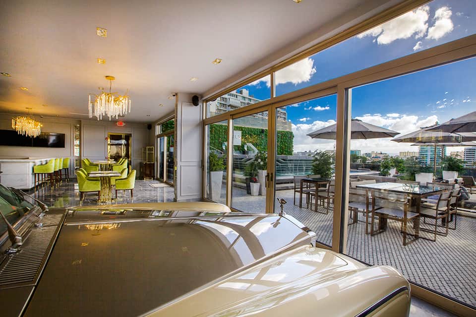 Luxury penthouse living area with floor-to-ceiling windows, fireplace, and city rooftop views