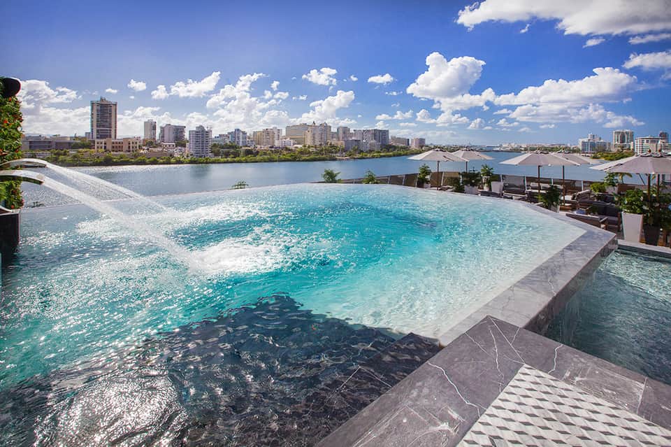 Rooftop infinity pool overlooking cityscape and waterfront with modern design