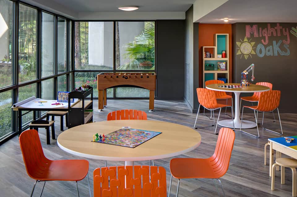 Colorful children's recreation room with round table, foosball, board games, and activity areas