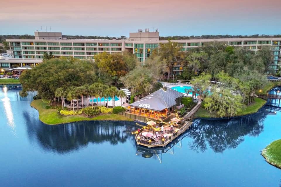 Resort aerial view with lazy river, pools, lagoon, and surrounding forest