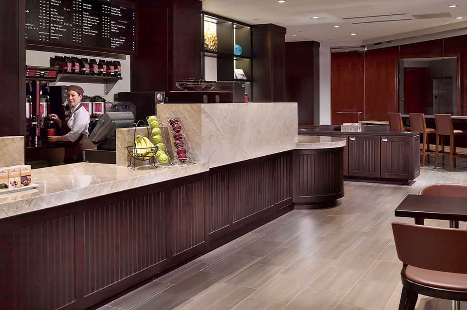 Upscale coffee shop counter with marble top and dark wood cabinetry