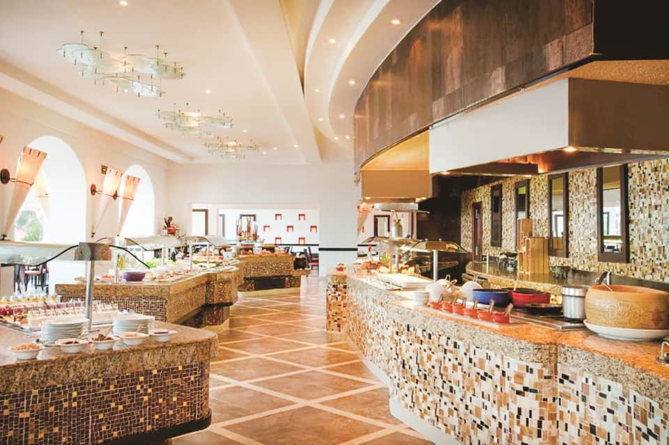 Spacious resort dining area with multiple buffet stations and elegant lighting