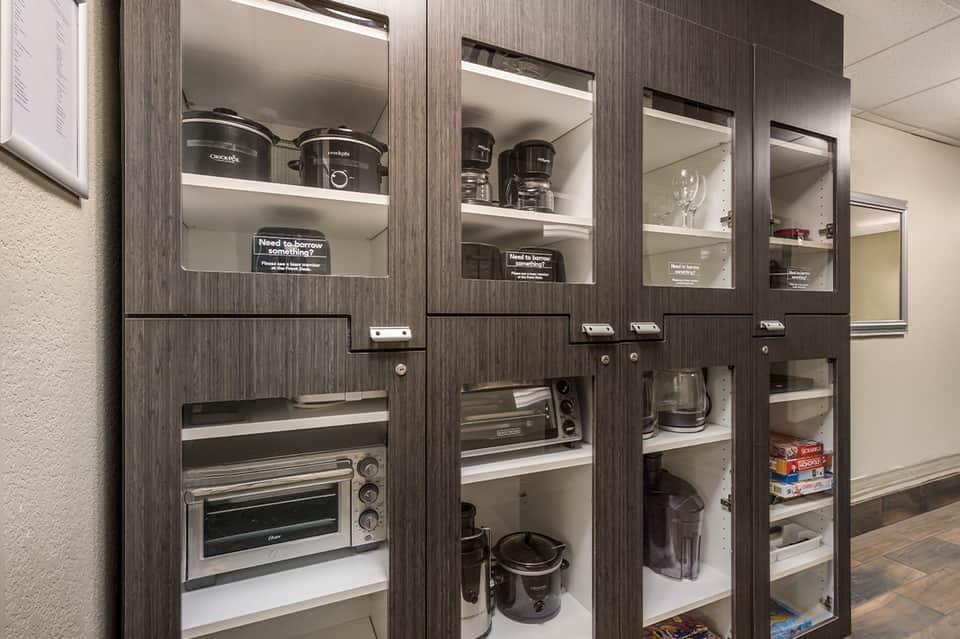 Modern kitchen appliance cabinets with glass doors displaying cooking equipment