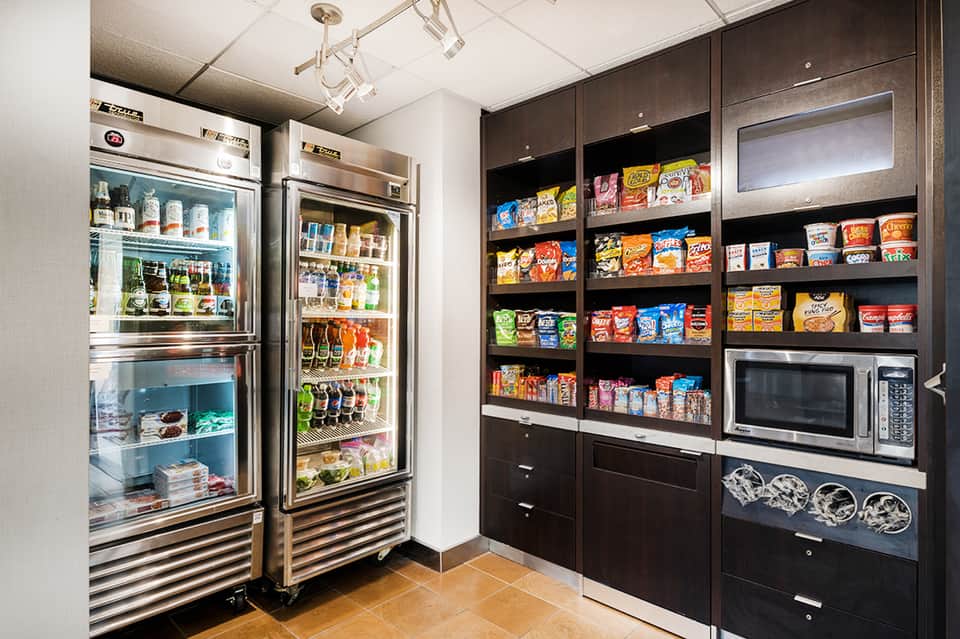 Hotel convenience store with refrigerated beverages and stocked snack shelves