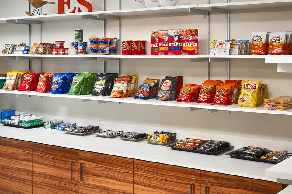 Retail shelf display with colorful snack packages, candy, and beverage products for purchase