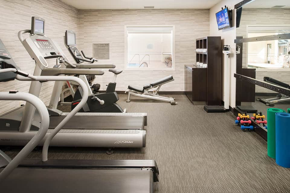 Fitness center with treadmills, exercise bikes, and workout equipment