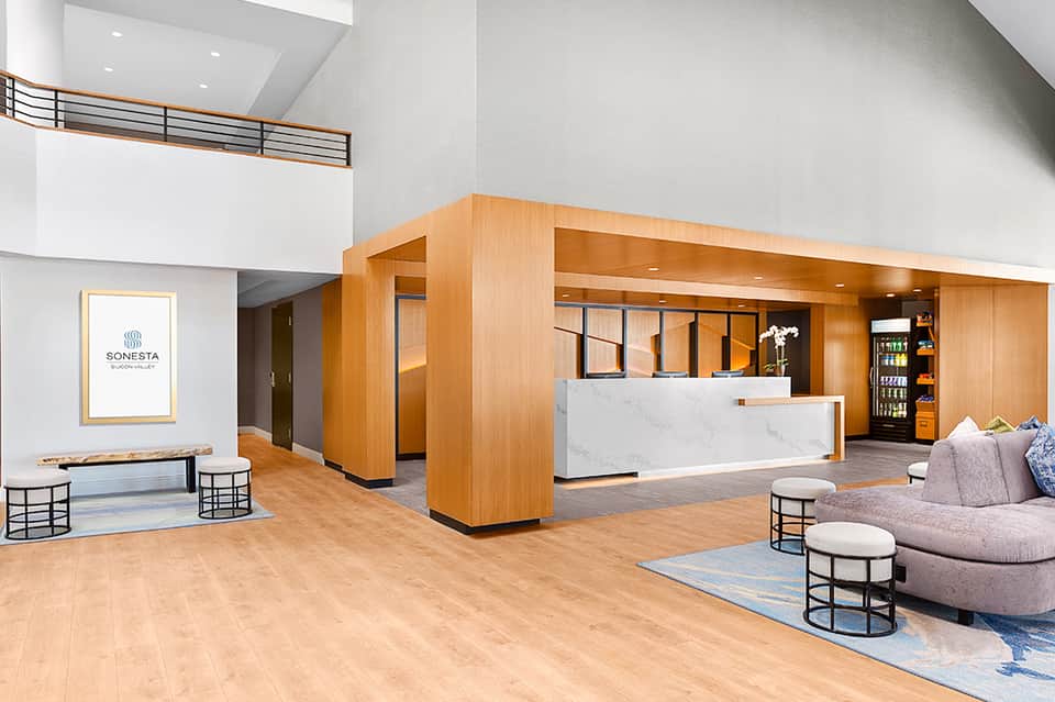 Modern spa reception lobby with wooden architectural details, marble counter, and contemporary furnishings