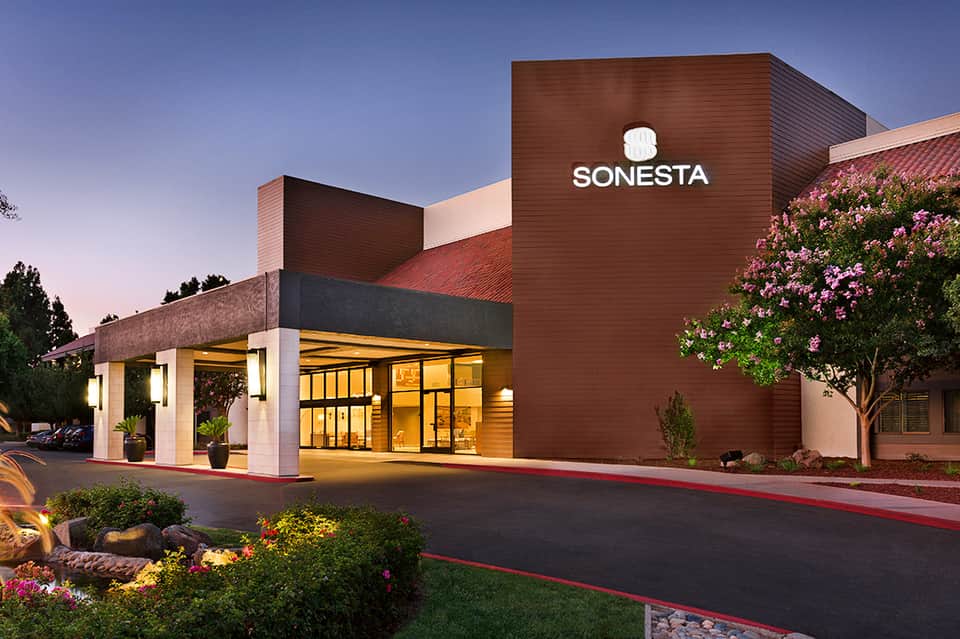 Modern resort building exterior with brick facade and SONESTA signage at dusk
