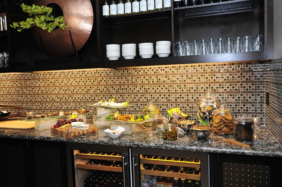Upscale food and beverage display with fresh produce, wine coolers, and elegant plated items