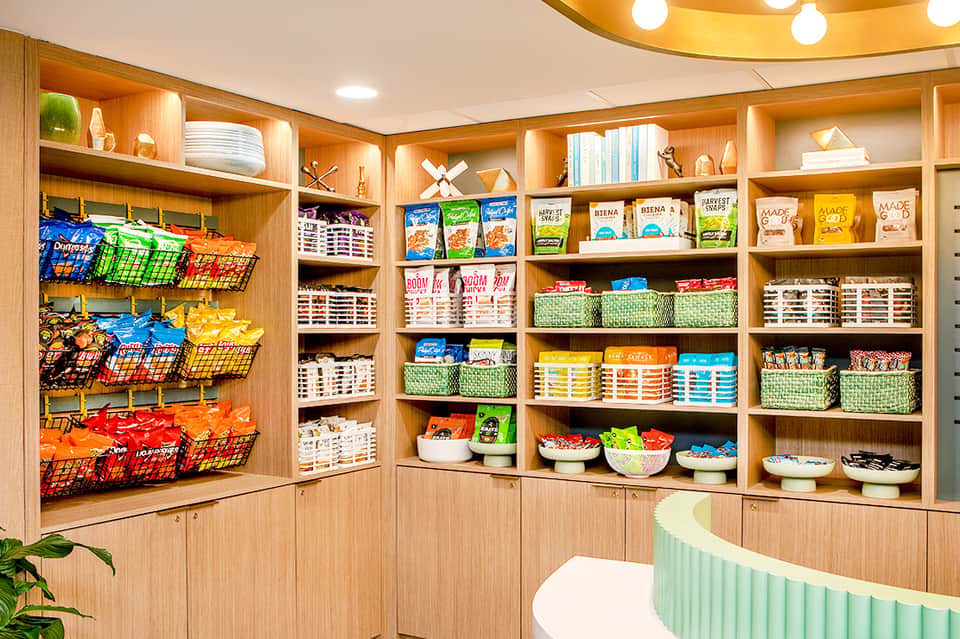 Indoor snack bar with wooden cabinetry, colorful product baskets, and organized shelving