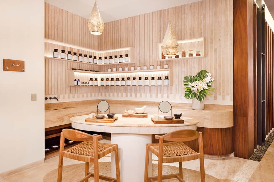 Spa treatment room with wooden accents, shelving of products, and dual vanity stations