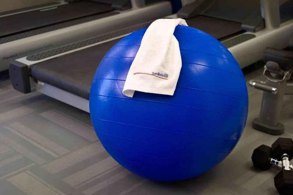 Blue exercise ball with white towel in fitness center near treadmill