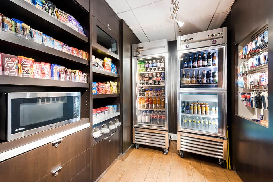 Hotel convenience store with refrigerated beverage cases, snacks, and microwave