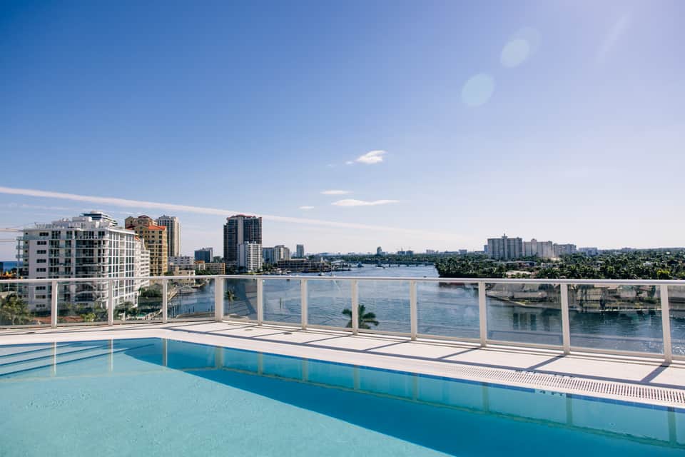 Rooftop pool overlooking waterway and cityscape with high-rise buildings and bridges