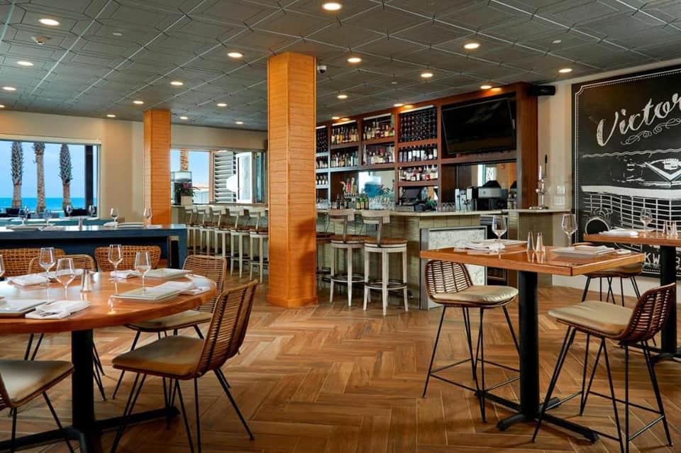 Modern beachfront restaurant with ocean views, bar, and contemporary seating