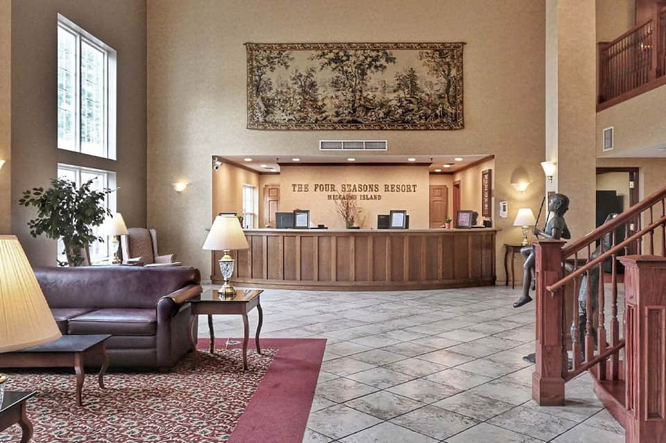 Four Seasons Resort lobby with reception desk, wooden railings, elegant furnishings and high ceilings