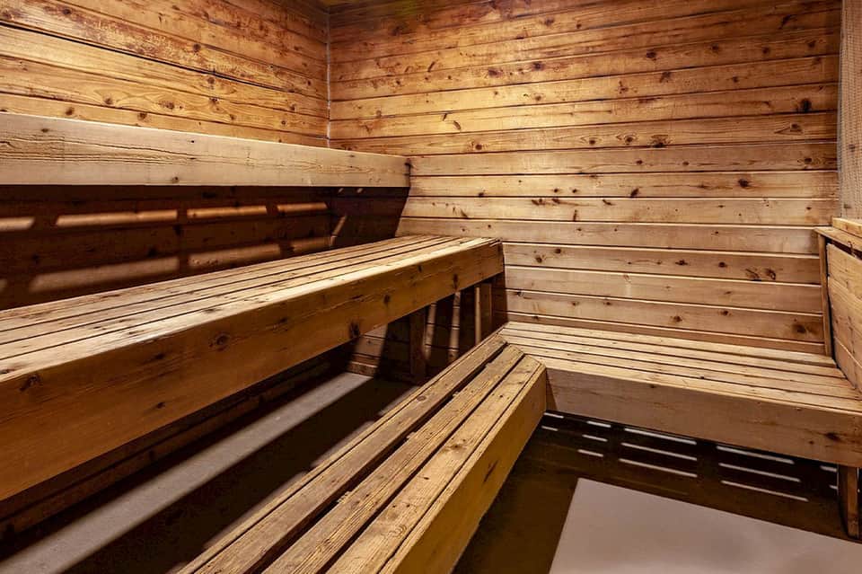Wooden sauna interior with benches and natural light through window