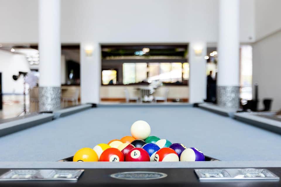 Billiards table with colorful balls arranged in a triangle in a hotel recreation room