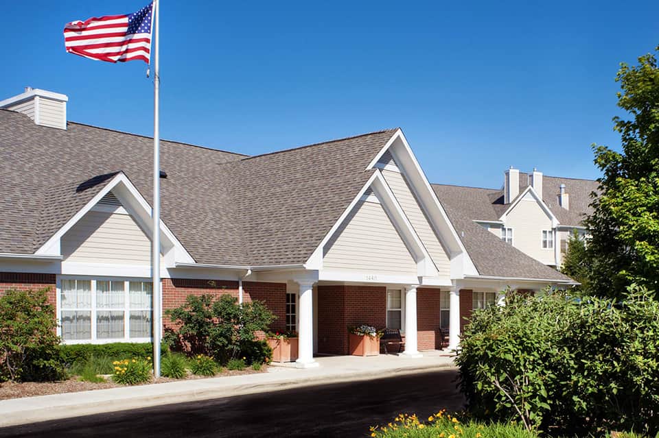 Brick hotel building with white trim and American flag