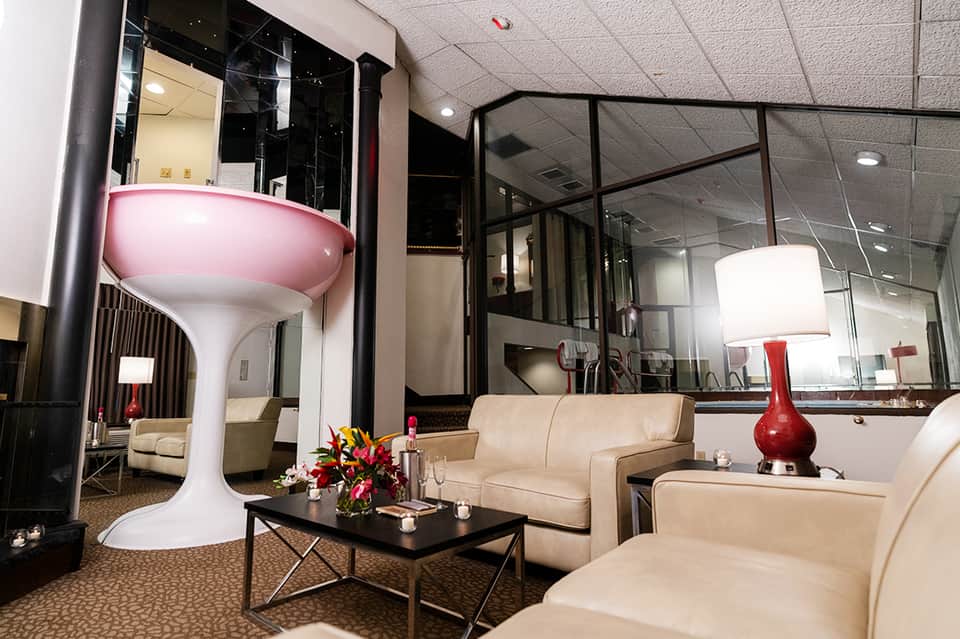 Modern hotel lounge with cream furniture, red accent lamp, and contemporary design