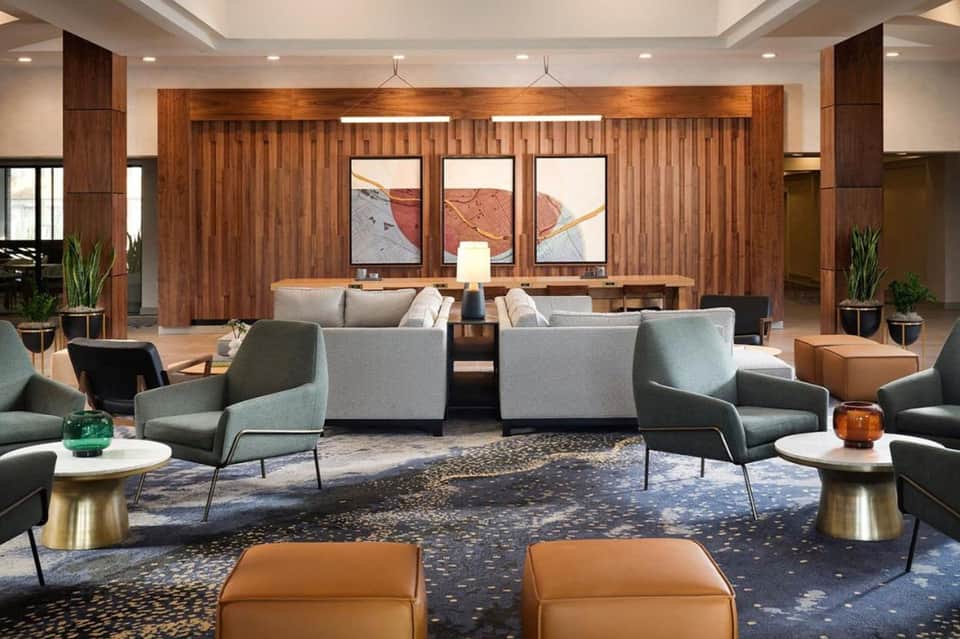 Spacious hotel lobby with wood paneling, seating areas, and contemporary art