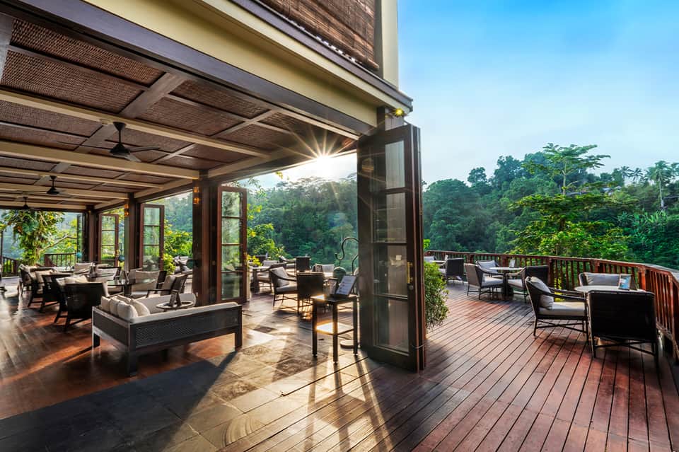 Open-air terrace with retractable shade screens, modern seating, and lush forest views