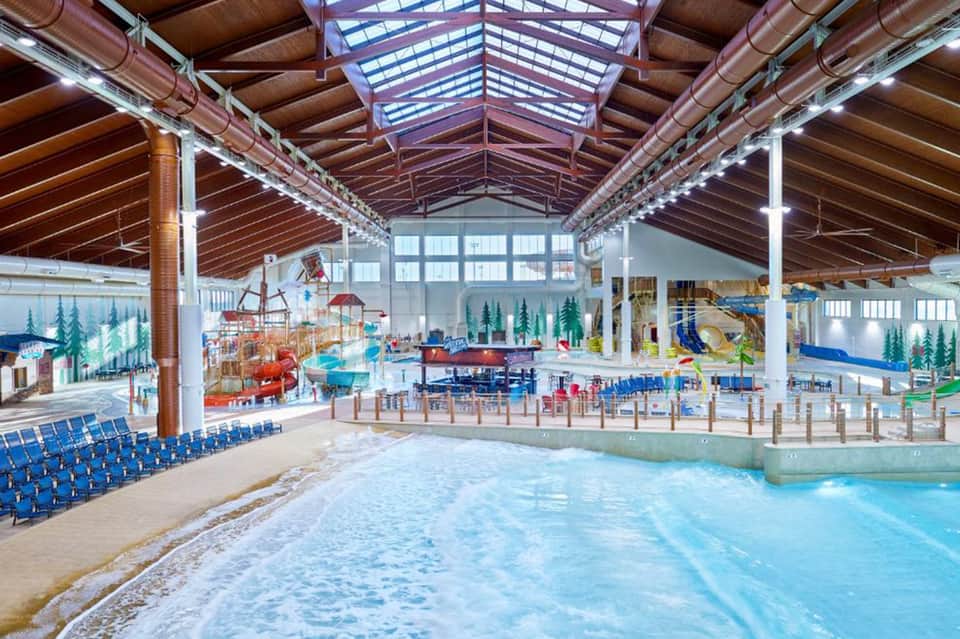 Indoor water park with wave pool, slides, and covered ceiling structure