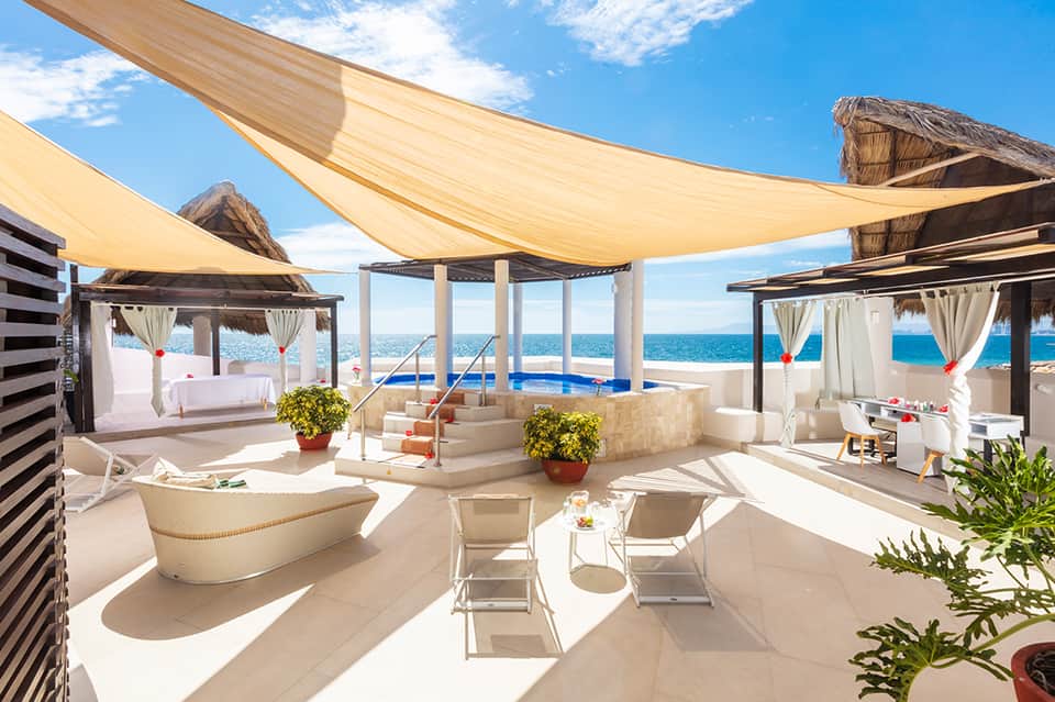 Luxury rooftop terrace with ocean view, cabanas, infinity pool, and sail shade coverings
