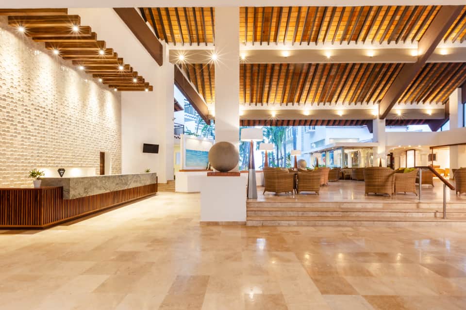 Modern hotel lobby with polished stone floors, reception desk, and contemporary design features