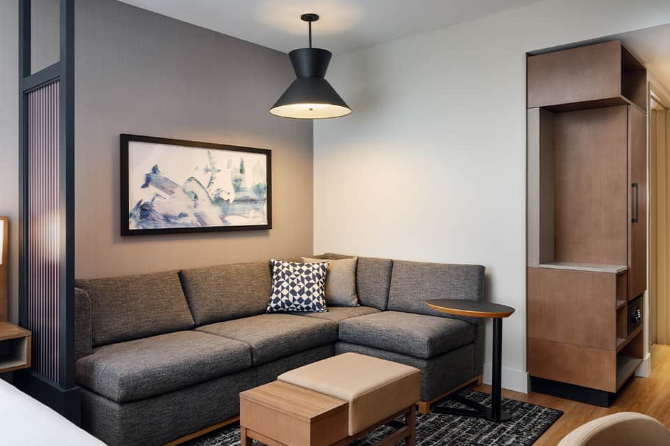 Modern hotel suite with gray sectional sofa and contemporary furnishings