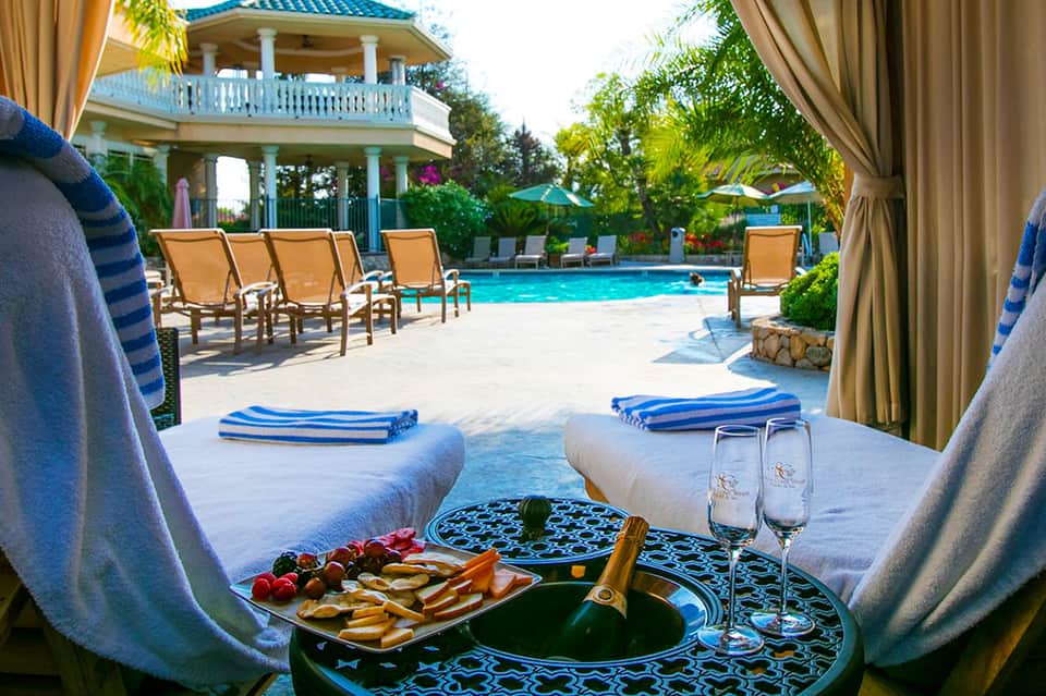 Luxurious poolside cabana setup with champagne, appetizers, and ocean-view resort grounds