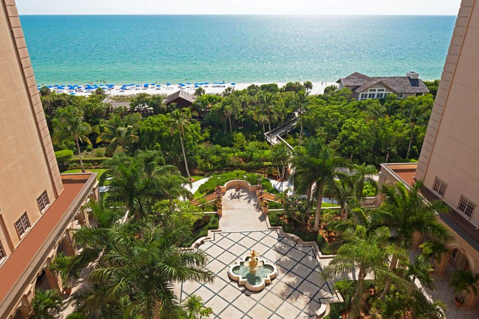 Elevated ocean view of beach, palm trees, and lush grounds from luxury beachfront resort