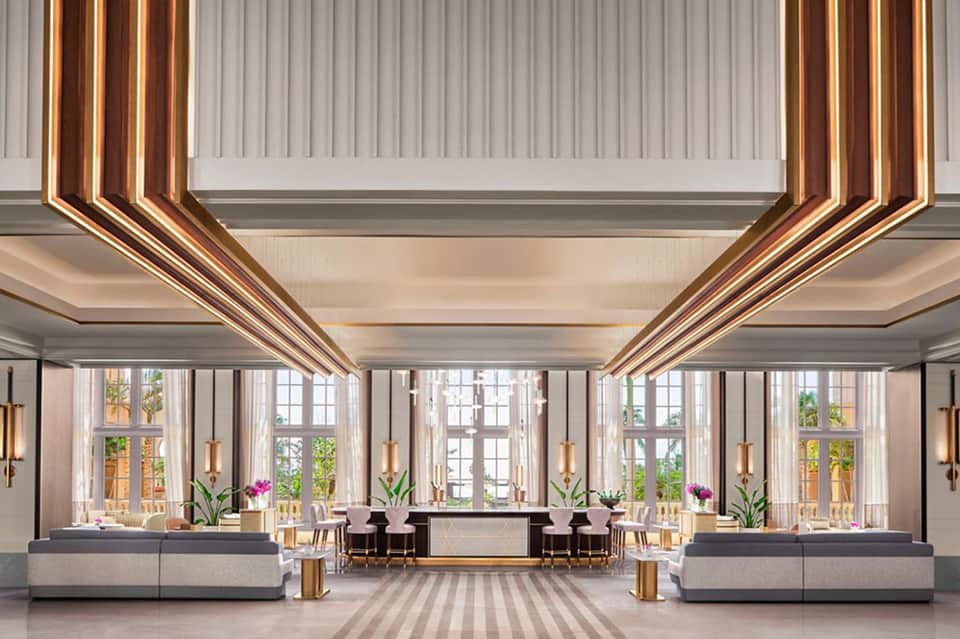 Luxury hotel lobby with dramatic copper linear ceiling elements and tall windows