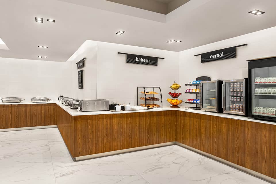 Hotel bakery and cereal bar counter with pastries and refrigerated beverages