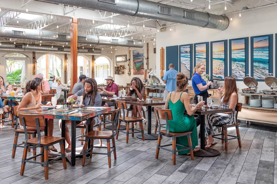 Modern restaurant interior with exposed brick, industrial ceiling, and dining guests