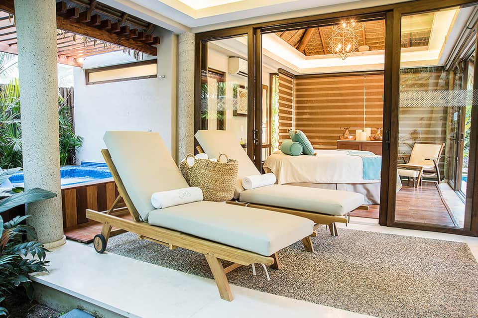 Luxury villa patio with wooden lounge chairs, small pool, bedroom view, and modern design