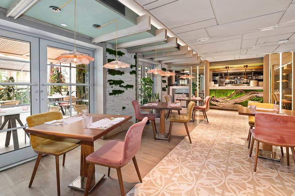 Contemporary restaurant interior with mid-century furniture, living walls, and pendant lights